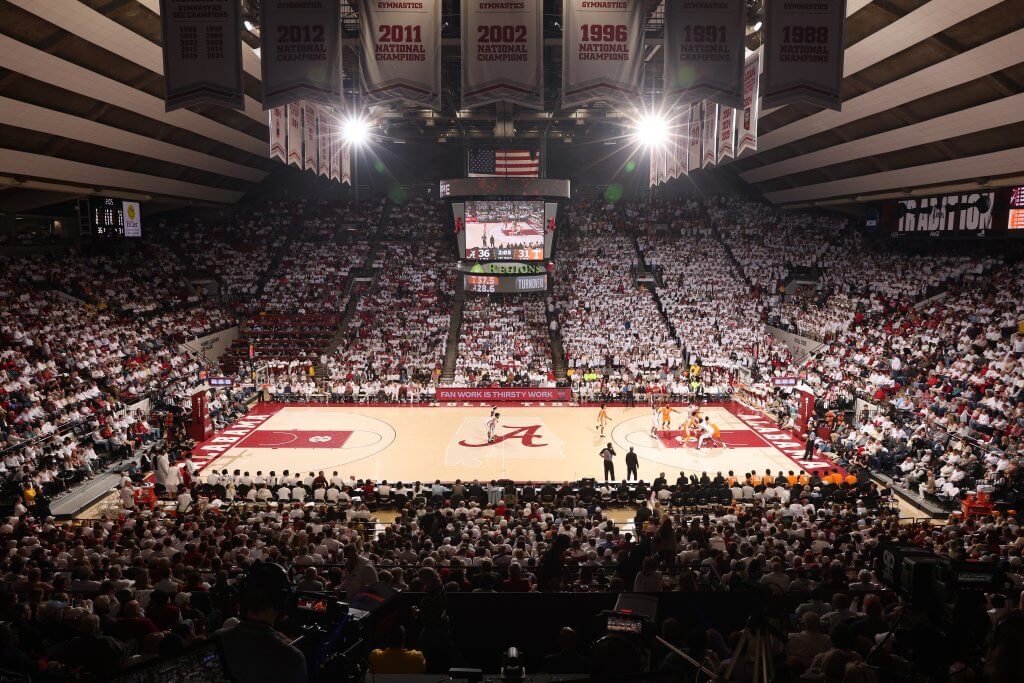 A packed basketball arena with a sea of red-clad fans cheering on their team during a game