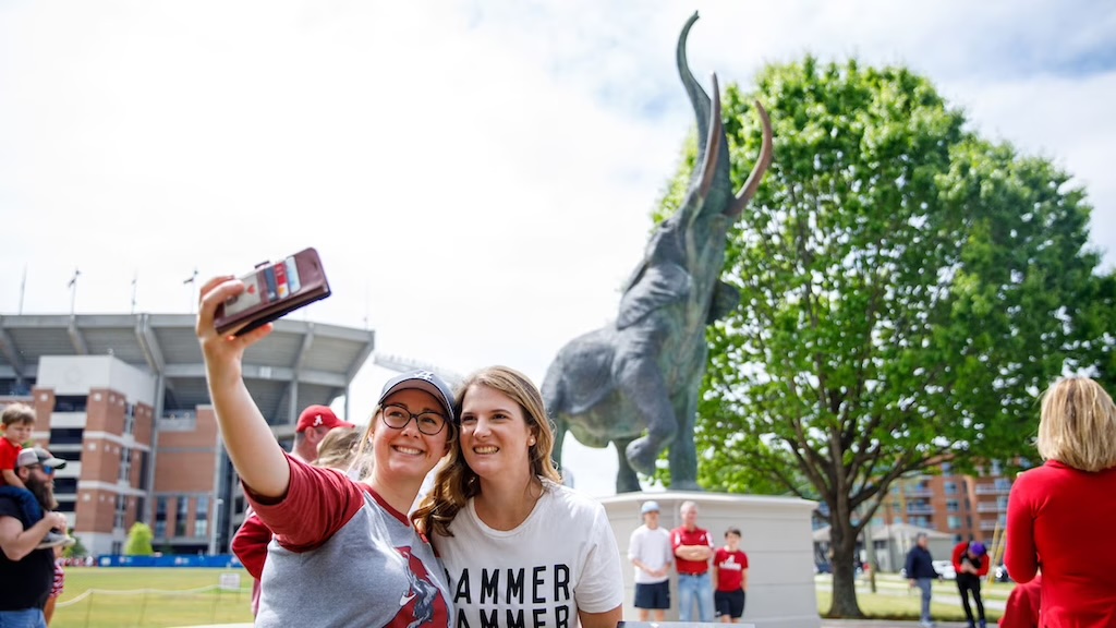 Mom and daughter take selfie at the University of Alabama's Tusca statue while visiting for Bama Bound freshmen orientation