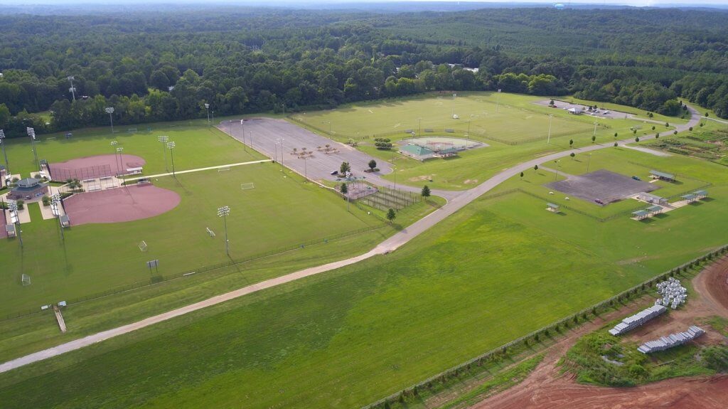 A sports complex with multiple fields and facilities, surrounded by lush greenery in Sokol Park North located in Northport, Alabama.