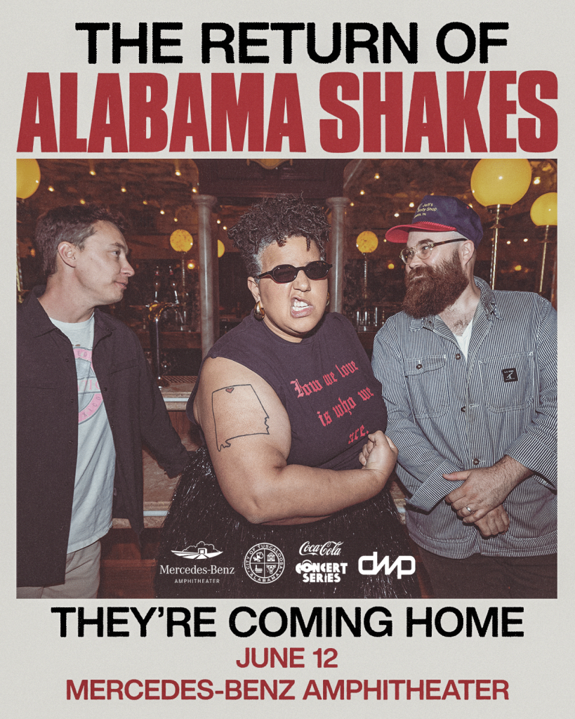 Three musicians, including a woman with a beard and a man with a beard, are posing together on a stage with a backdrop that reads 'The Return of Alabama Shakes'. They are dressed in casual attire and appear to be smiling in Tuscaloosa, Alabama.