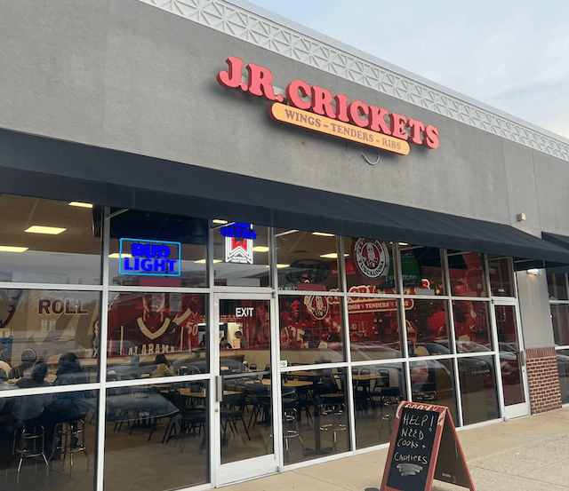 A casual dining restaurant with a large red sign advertising wings, tenders, and ribs in Tuscaloosa, Alabama.