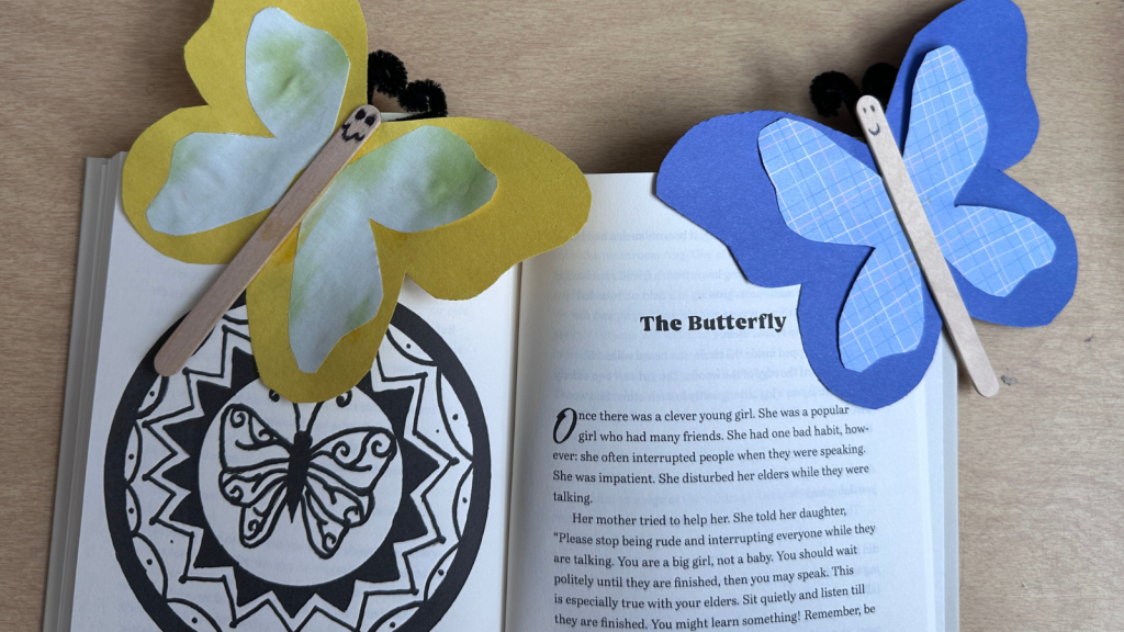 Handmade paper butterfly bookmarks with smiley faces adorn an open book titled 'The Butterfly' in Tuscaloosa, Alabama.