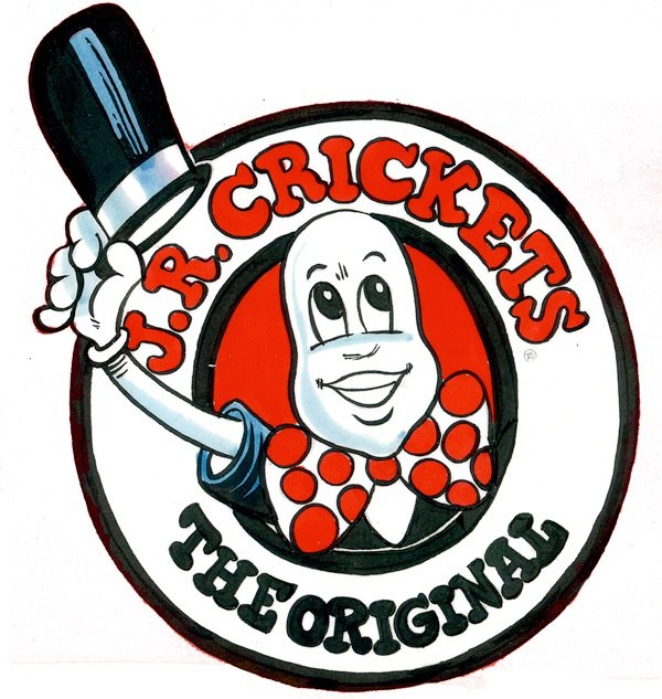 A cheerful cartoon character wearing a top hat and bow tie, holding a cricket-themed sign in Tuscaloosa, Alabama.