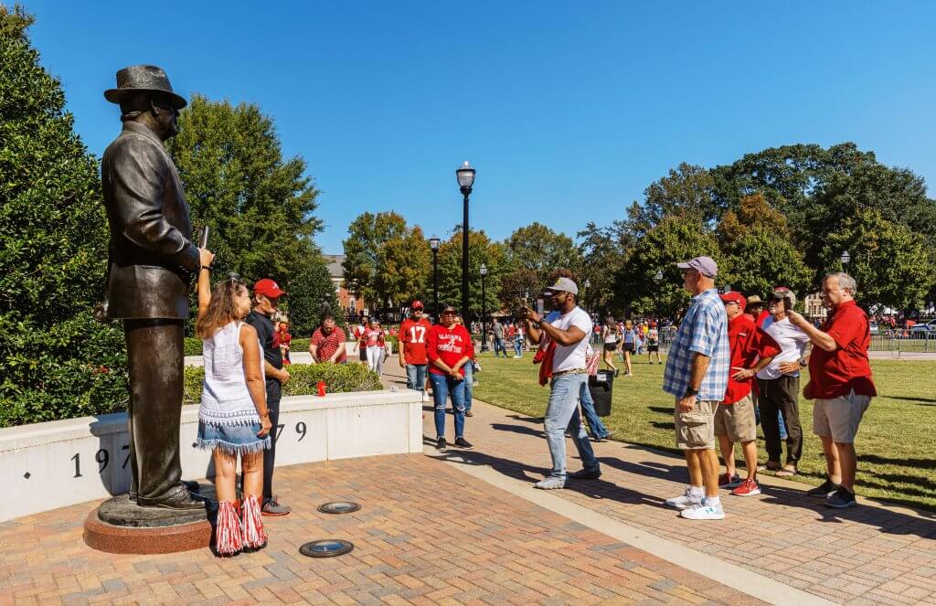 Alabama football fans gathered around the Coach Paul “Bear” Bryant statue on Champions Lane in front of Bryant-Denny Stadium in Tuscaloosa, Alabama.