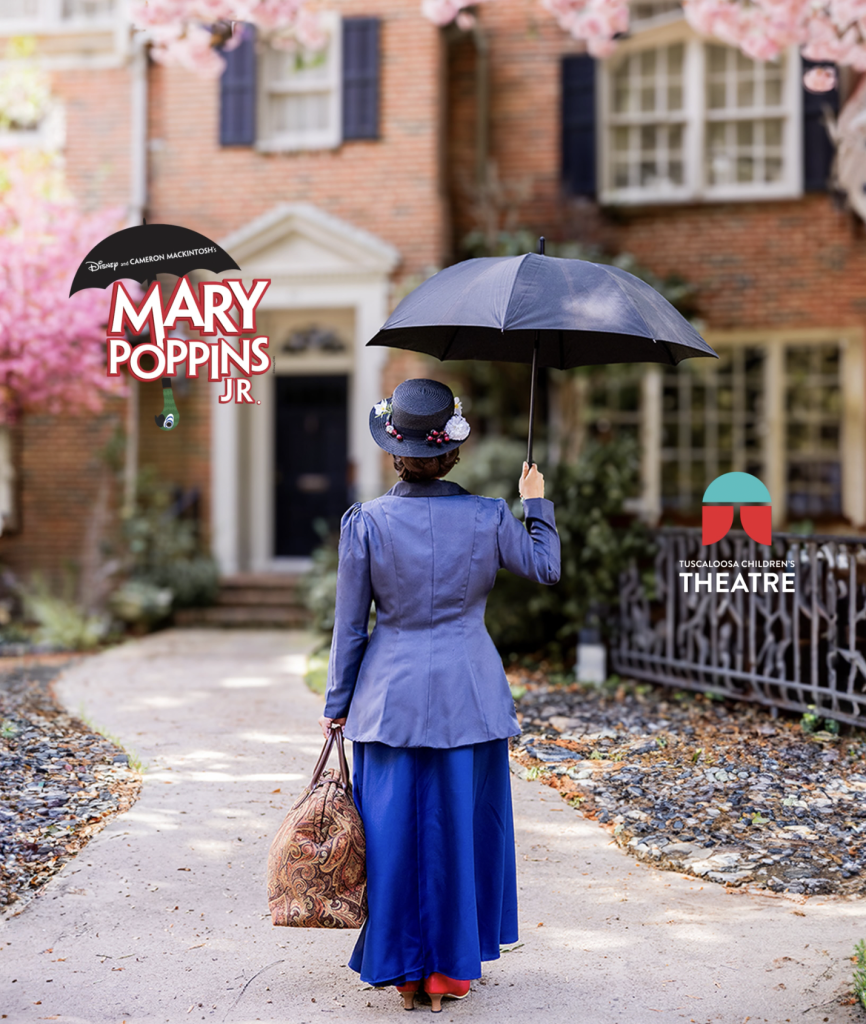 A person dressed as Mary Poppins stands on a path holding an umbrella and bag in Tuscaloosa, Alabama.