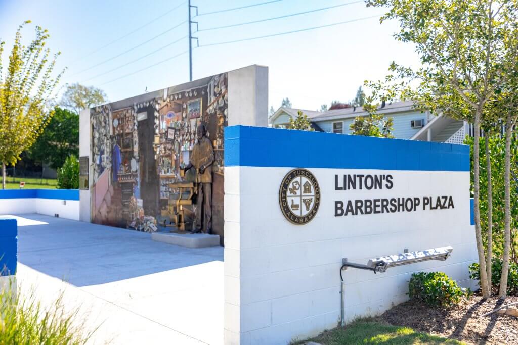 A memorial plaza in Tuscaloosa featuring a mural and statue of a barber in Tuscaloosa, Alabama.