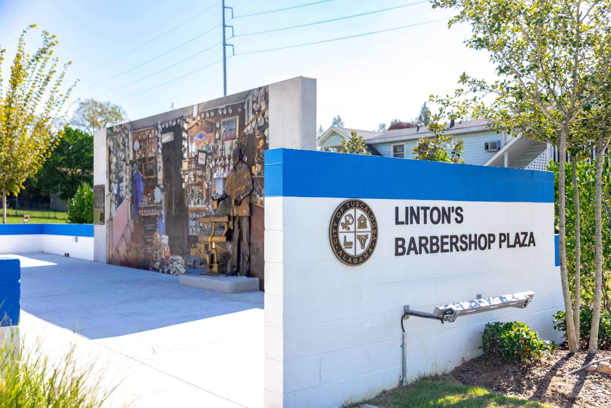 A memorial plaza in Tuscaloosa featuring a mural and statue of a barber in Tuscaloosa, Alabama.